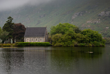 Saint finbarrs oratory reflecting in the still waters of gougane barra national park, ireland