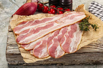 Sliced pork bacon over board