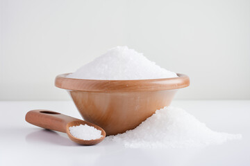 Fine grains of salt sprinkled neatly on a bright white background, forming a soft, delicate texture.