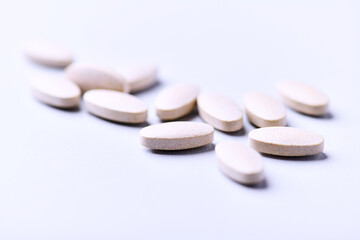 Ashwagandha (Withania somnifera) tablets. Concept for a healthy dietary supplementation. Bright paper background. Close up. Copy space.