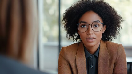 A Professional Woman in Business Attire Engaging in a Conversation in a Modern Office Setting