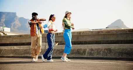 Urban, fun and group of happy people with dance, diversity and cool streetwear style at sunset. Excited, smile and gen z friends with city fashion, positive energy and bonding in street together. © Flashizzle/peopleimages.com