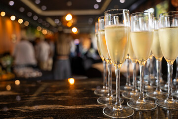 Glasses of champagne at the Banquet, white sparkling wine in wine glasses, festive mood and party in background.