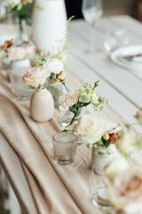 Elegant neutral coloured wedding table scape with flowers and candles