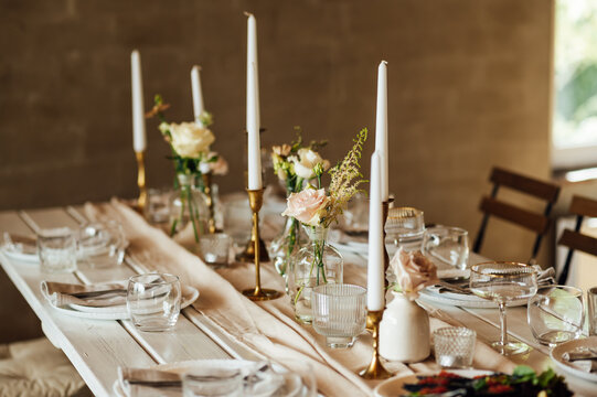 Elegant neutral coloured wedding table scape with flowers and candles
