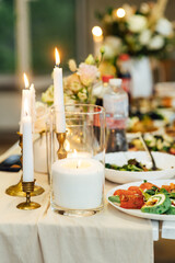Elegant neutral coloured wedding table scape with flowers and candles