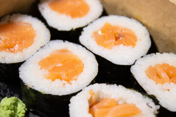 Close up of fresh sushi maki with salmon in a take away box