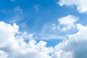 Fluffy white clouds drift across a vibrant blue sky, creating a breathtaking natural spectacle