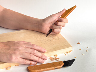 Precision woodcarving techniques. Hands crafting intricate patterns on wood