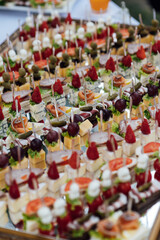 A large selection of various snacks for guests on a mirror surface. Buffet before an important event