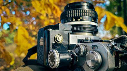 film vintage camera lies on the background of autumn nature