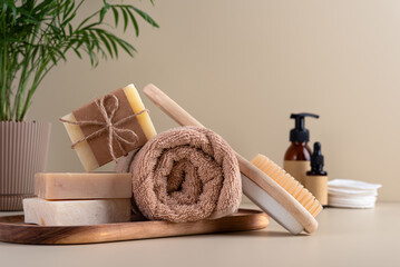 Natural handmade soap bars and fluffy towel in bathroom with plant and toiletries
