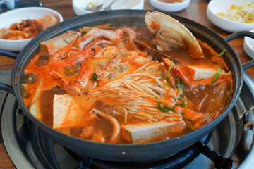 Tofu seafood soup with seafood such as clams and blue crabs and vegetables such as mushrooms