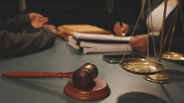 Judge gavel with Justice lawyers having team meeting at law firm background. Concepts of Law and Legal services.