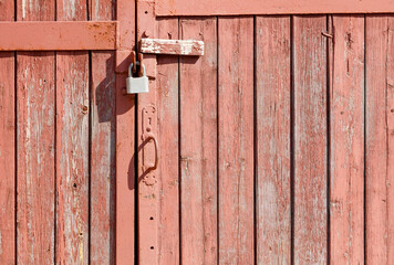 A rusty lock on a wooden door