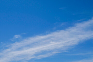 The sky is blue with a few clouds scattered throughout. The clouds are white and fluffy, giving the sky a peaceful and serene appearance
