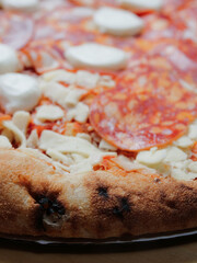 Uncooked pizza with meat products and buffalo cheese. Close up. Italian style dish with high quality ingredients. Fast food with premium products.