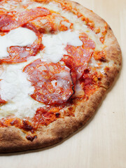 Cooked pizza with meat products and buffalo cheese. Close up. Italian style dish with high quality ingredients. Fast food with premium products.
