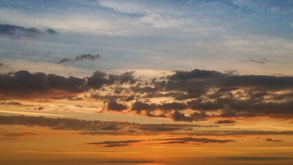 Fototapeta premium Summer evening sky in the picturesque clouds, lit by the rays of the setting sun.