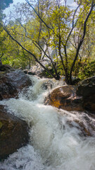 The waterfall has rocks around 