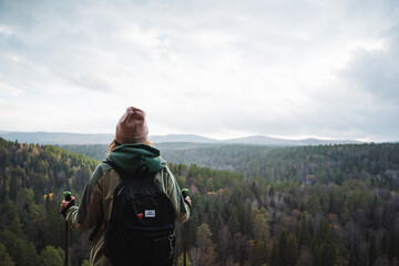 An adventurous hiker standing at a viewpoint, admiring the breathtaking scenic mountain landscape...