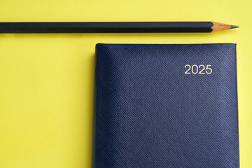 diary 2025  and pencil on the yellow background