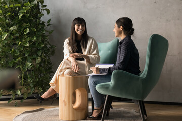 Multiethnic business colleagues women discussing work project in office lounge zone, talking,...