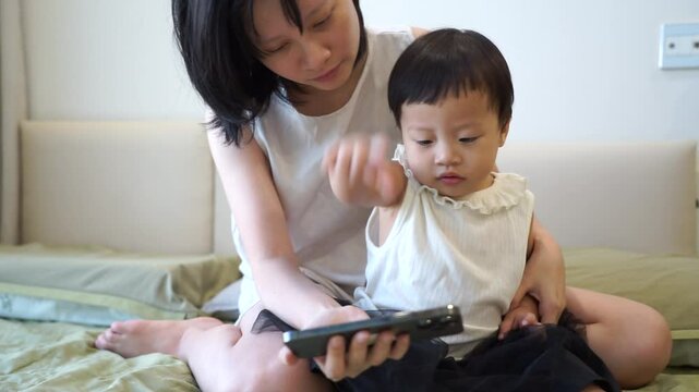 Young Asian mother playing with her daughter at home