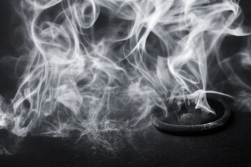 Smoke swirling around a dark ring on a black surface, creating a mysterious atmosphere