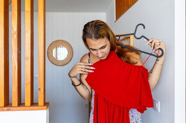 Trans woman choosing a dress at home, reflecting identity