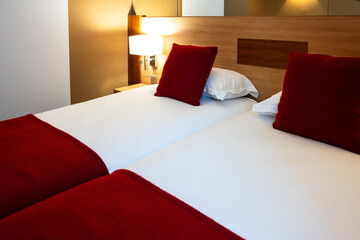 twin bed in a hotel room with white and red linen