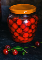 Homemade cherry preserves. Fresh pitted cherries in sugar syrup in a glass jar. Canned organic food from the garden