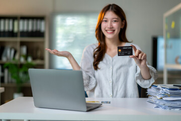A woman is holding a credit card and smiling