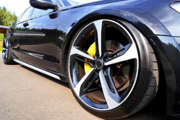 Alloy wheel with calipers and racing brakes of the sport car. Racing brake disc and low profile tyres. Race car test driving. Lower-profile tires of drag and drift cars. High-performance sports cars. © MaxSafaniuk