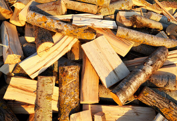 Firewood background, texture. Chopped firewood close up. Chopping wood and cutting timber. Preparation of firewood in village for heating the house in winter. A pile of firewood close-up.