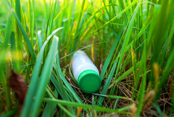 Plastic bottle in grass. Discarded plastic bottle. Throwing garbage in nature, pollution. Waste...
