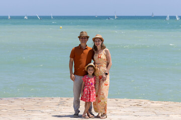 Family by the sea with hat