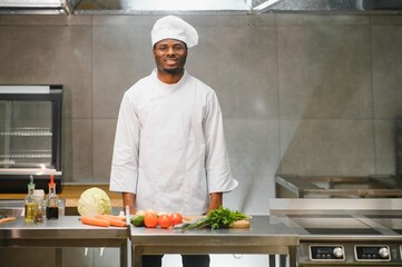 African American chef cooking tasty salad in kitchen
