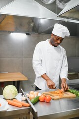African American chef cooking tasty salad in kitchen