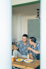 Two friends share laughter and food in a cozy cafe atmosphere