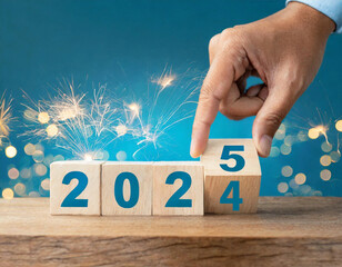 Hand turning wooden blocks to mark the countdown from 2024 to 2025 during a New Year celebration