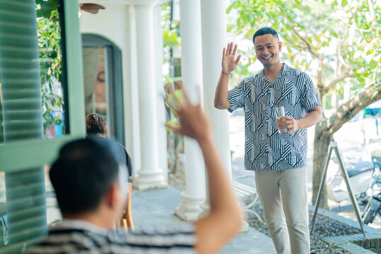 Two friends enjoy a sunny outdoor meetup filled with cheerful greetings and great memories
