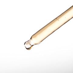 Pipette with serum, gel, oil or other cosmetic product on white background.