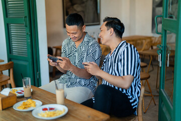 Friends enjoying a lighthearted moment in a caf with delicious food