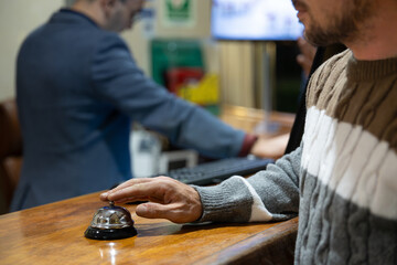 Man call hotel reception with finger push a bell in lobby hotel. hotel concept.