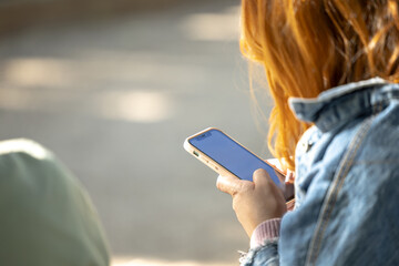 close-up arm of young adult woman checking his smartphone social media news browsing the internet on a summer terrace on a muddy day on vacation
