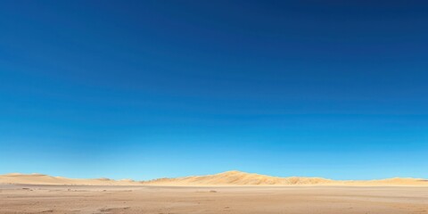 Minimalist desert landscape under a clear blue sky.