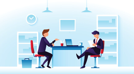 In a contemporary office, two men in suits converse around a desk, with one gesturing while the other reviews documents, highlighting a collaborative atmosphere.