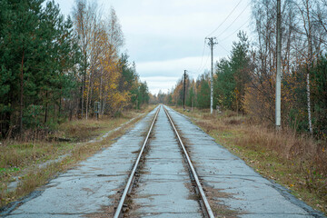 Inactive railway line, crossing the asphalt road.