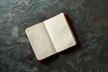 Open blank notebook on a textured dark surface in a well-lit space